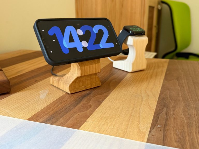 Apple Watch auf einer handgefertigten Ladestation aus hellem Holz auf einem Holztisch