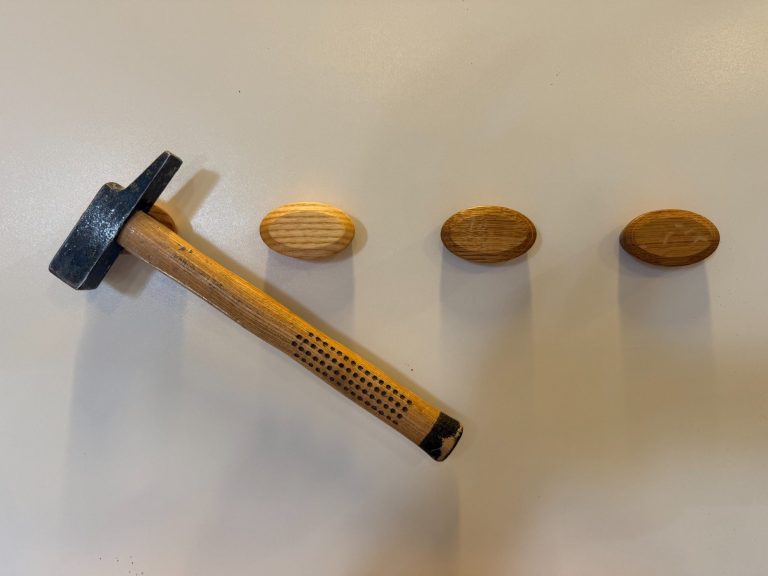 Schlüsselhalter demonstriert die Haftkraft der Magnete, es hängt ein Hammer mit 500g daran